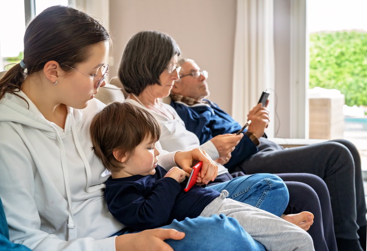 Familie mit mehreren Generationen zusammen an ihren Smartphones im Internet